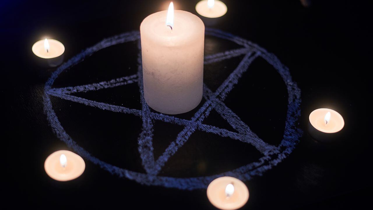 Pentagram and burning candles. The magical ritual of Satanism, invocation of spirits, spiritualistic sessions.