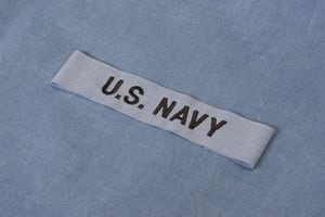 US NAVY branch tape on navy blue uniform background