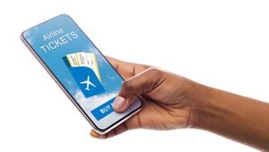 Comprar boletos de avión en línea. Primer plano del vuelo de reserva de la mano de Afro Lady en la aplicación móvil aislada en blanco. Panorama, Espacio Libre