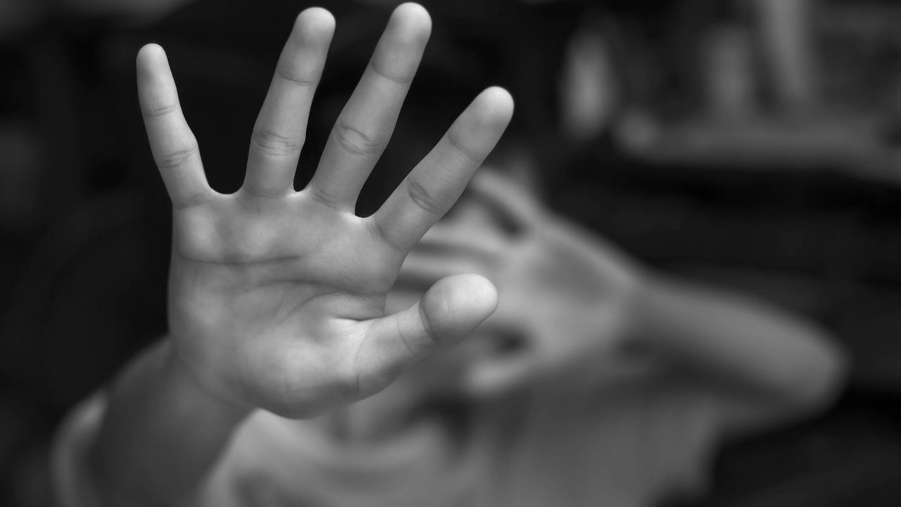 Muchacho que muestra el gesto de PARADA con la mano. Concepto de violencia doméstica y abuso infantil.