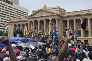 Manifestantes, muchos con banderas de Sri Lanka, se reúnen frente a la oficina del presidente.