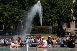 People cool off beside the fountains in Trafalgar Square in central London on June 17, 2022, on what is expected to be the hottest day of the year so far in the capital. - A Level 3 Heat-Health alert for London, the East of England and the South East has been announced to help protect health services, the UK Health Security Agency (UKHSA) has said, Friday. (Photo by CARLOS JASSO / AFP)