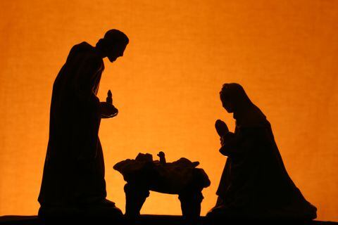 Christian Christmas nativity scene with Joseph,baby Jesus and Mary in silhouette on gold background. Horizontal image would be good for Christian and religious Christmas use.