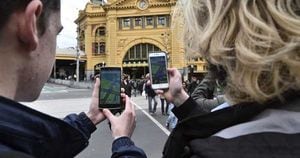Dos estudiantes prueban el nuevo juego "Pokémon Go" en su móvil en Melbourne, Victoria, Australia, hoy, 12 de julio de 2016. Foto: EFE.