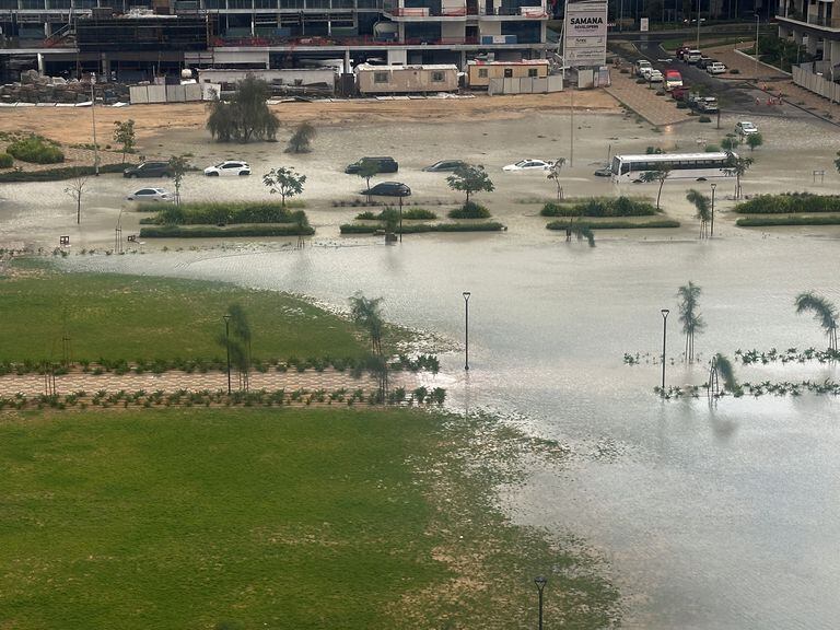 Los carros circulan por una calle inundada durante una tormenta en Dubai