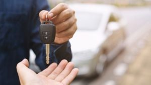 La llave del auto, el hombre de negocios entrega la llave del auto a la otra mujer en el fondo del auto.