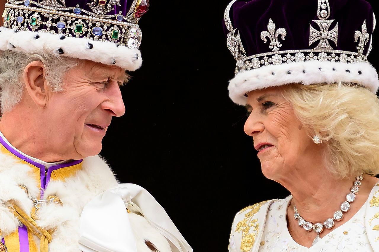 El rey Carlos III de Gran Bretaña y la reina Camila se miran desde el balcón del Palacio de Buckingham después de su coronación, en Londres