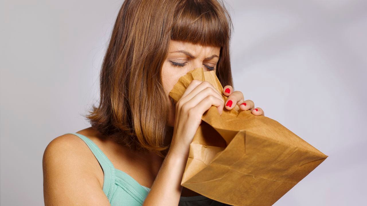 Mujer hiperventilando, ansiedad, estrés, fatiga, palpitaciones, trastorno