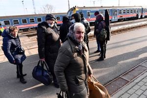 Ukrainian people leave a train that carried 275 people, to arrive in Zahony, Hungary, a border town with Ukraine, Friday, Feb. 25, 2022. Thousands of Ukrainians are fleeing from war by crossing their borders to the west in search of safety. They left their country as Russia pounded their capital and other cities with airstrikes for a second day on Friday. (AP Photo/Anna Szilagyi)