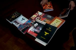 Un oficial de la policía federal devuelve los libros confiscados dentro de cajas después de exhibirlos a la prensa en la sede de la Policía Federal en Buenos Aires, Argentina, el miércoles 13 de septiembre de 2023.  (AP Foto/Natacha Pisarenko)