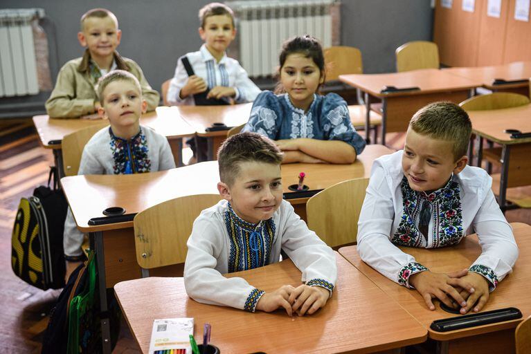 Alumnos de tercer grado asisten a la primera lección del nuevo año escolar en la ciudad de Lviv, en el oeste de Ucrania, el 1 de septiembre de 2022. - Las autoridades ucranianas dijeron que 2.199 instituciones educativas habían resultado dañadas como resultado de bombardeos y bombardeos, 225 de ellas completamente dañadas. destruido. La mitad de las 23.000 escuelas encuestadas por el Ministerio de Educación, alrededor del 51 por ciento, están equipadas con las instalaciones de búnker necesarias para comenzar las clases fuera de línea. (Foto de YURIY DYACHYSHYN / AFP)