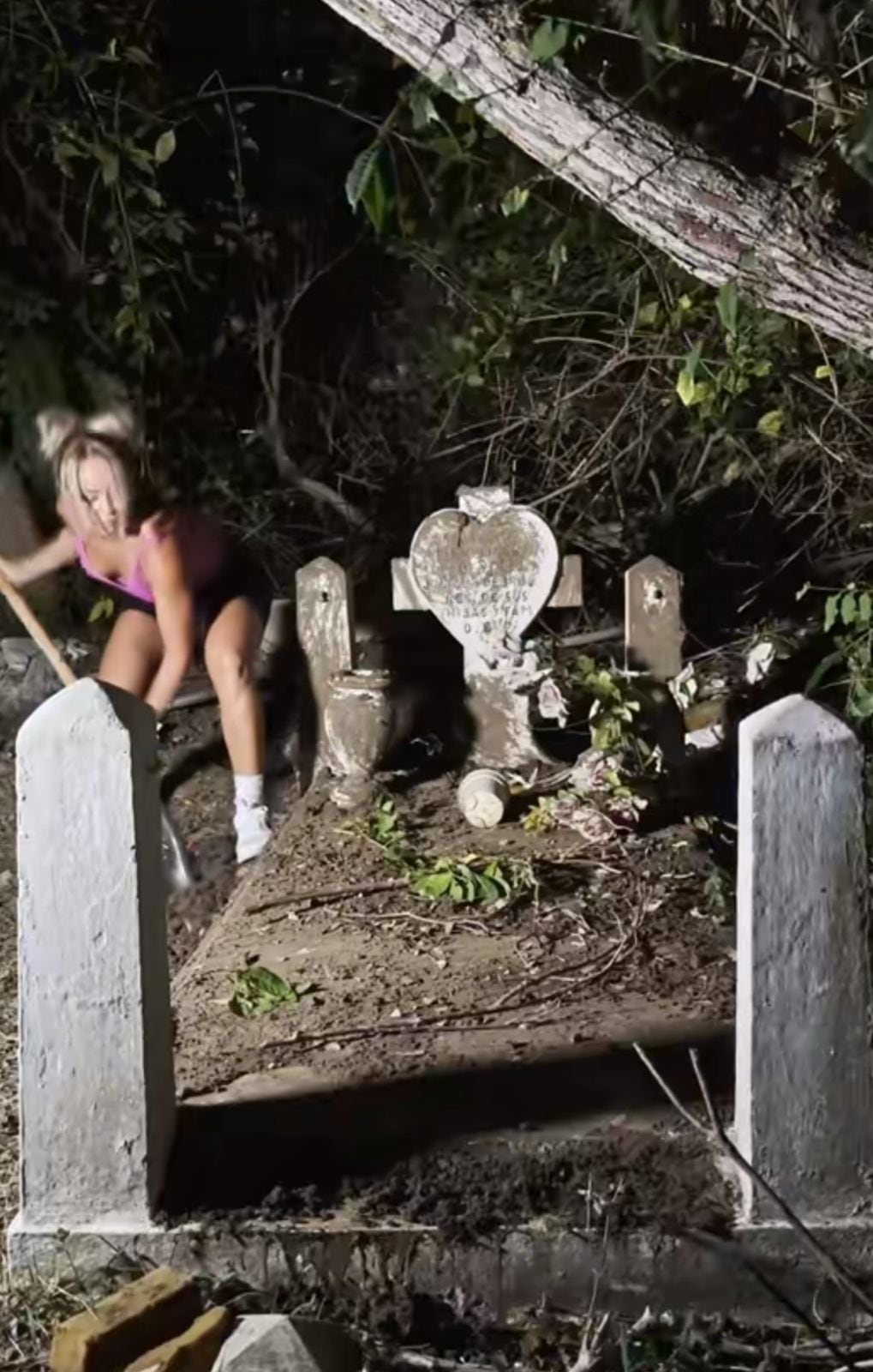 La mujer usa sus propios productos de aseo para su trabajo en el cementerio
