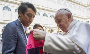 A photo taken and handout on June 16, 2021 by The Vatican Media shows Colombia's cyclist Egan Bernal (L) and his girlfriend Maria Fernanda Gutierrez (Rear C) presenting Pope Francis with an Ineos Grenadier team jersey and a bicycle,
