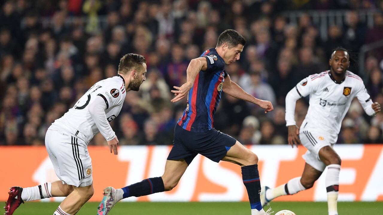 Manchester United's English defender Luke Shaw (L) fights for the ball with Barcelona's Polish forward Robert Lewandowski during the UEFA Europa League round of 32 first-leg football match between FC Barcelona and Manchester United at the Camp Nou stadium in Barcelona, on February 16, 2023. (Photo by Josep LAGO / AFP)