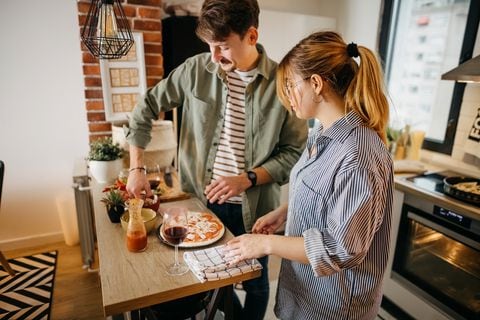 Young smiling couple baked a pizza in the kitchen