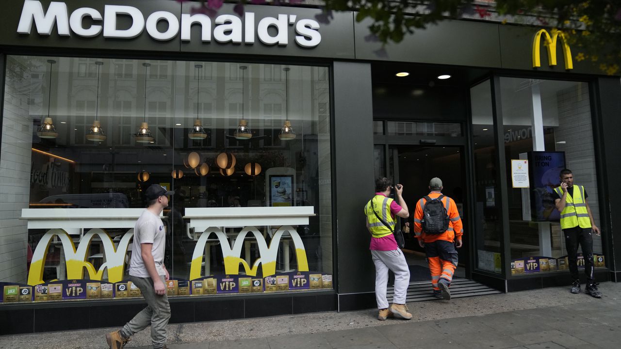 Los clientes entran en una sucursal de un restaurante McDonald's, en Londres, el martes 24 de agosto de 2021. McDonald's dice que ha retirado los batidos del menú en los 1.250 restaurantes británicos debido a problemas de suministro derivados de la escasez de camioneros. La cadena de comida rápida dice que también está experimentando escasez de bebidas embotelladas. (Foto AP / Beca Alastair)