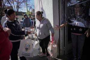 Las mujeres llevan bolsas de comida entregadas por un comedor social que sirve comidas calientes en Buenos Aires, el miércoles 10 de mayo de 2023. Muchas personas dependen de las entregas diarias de alimentos en medio de una inflación galopante. (Foto AP/Víctor R. Caivano)
