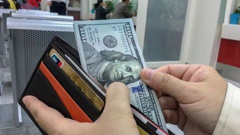 BEIJING, CHINA - 2017/04/18: A Chinese tourist exchange some US Dollar banknotes in a bank, preparing for a travel abroad.  According to the report of UNWTO,  Chinese mainland travelers have spent as high as $261.1 billion abroad,  an increase of 12% over the year of 2015, accounting for about 20.9% of total consumption.  The number of outbound tourists grew by 6%, reaching 135 million. (Photo by Zhang Peng/LightRocket via Getty Images)