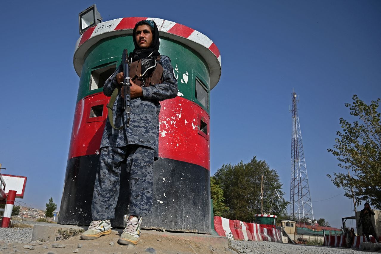 In this picture taken on October 3, 2021, a Taliban fighter working as part of a police force stands guard at the entrance gate of a police district in Kabul. - The Taliban's new police force already counts about 4,000 men in the capital, says a Kabul police spokesman, insisting the city is far safer than before, as the hardline group builds a police force from scratch. (Photo by WAKIL KOHSAR / AFP) / TO GO WITH Afghanistan-police-Taliban,FOCUS by Elise BLANCHARD