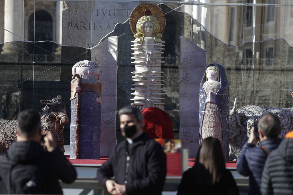 Faithful stop by the nativity scene as they wait for the start of Pope Francis'Angelus noon prayer in St. Peter's Square, at the Vatican, Sunday, Dec.13, 2020. (AP Photo/Gregorio Borgia)