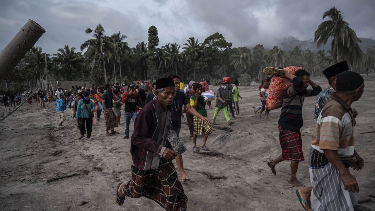 Los aldeanos rescatan sus pertenencias en un área cubierta de ceniza volcánica en Sumber