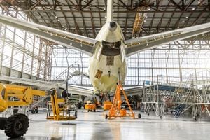 Passenger aircraft on service in an aviation hangar rear view of the tail, on the auxiliary power unit