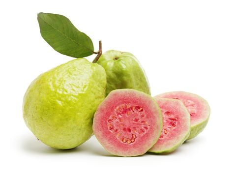 Fruta de la guayaba con hojas sobre fondo blanco