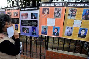 Una mujer mira las fotos de varias víctimas de los 'falsos positivos' de Soacha, en la plaza central de ese municipio de Cundinamarca.
