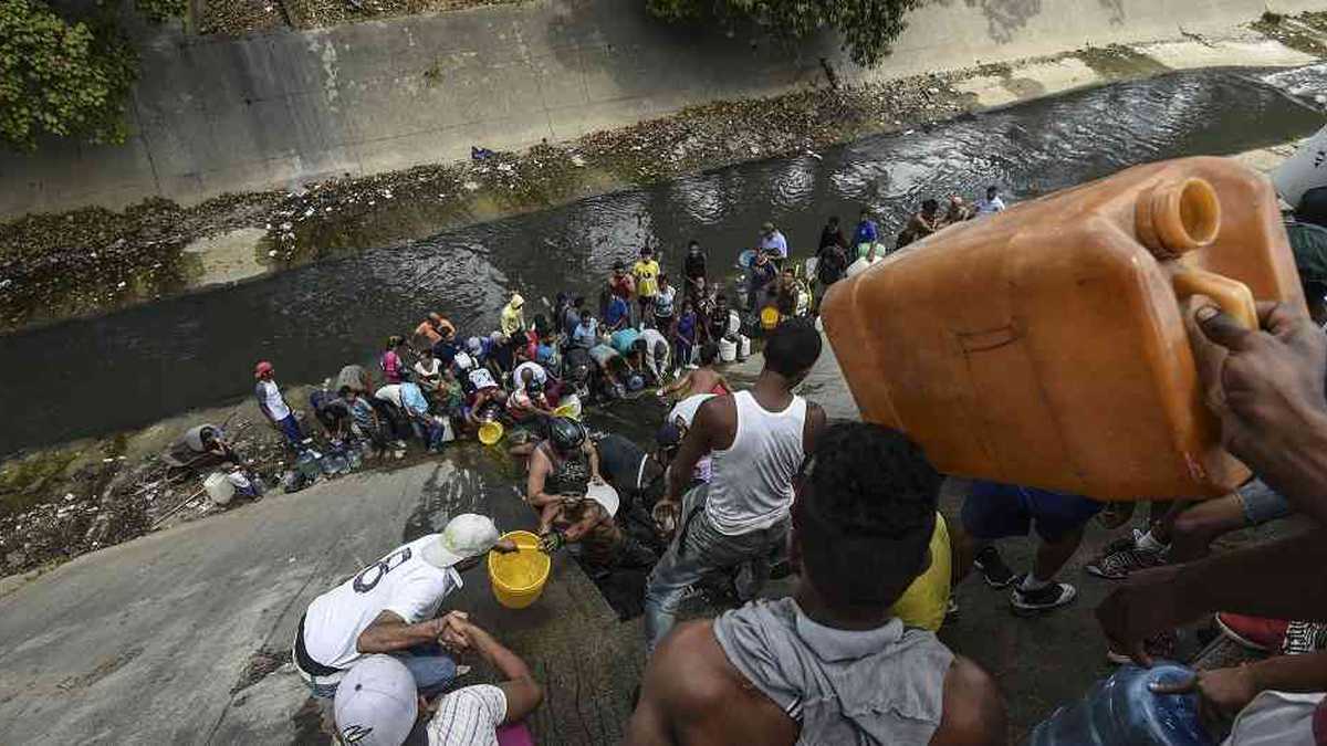 La falta de abastecimiento ha llevado a los venezolanos a recoger agua de los ríos. En esta escena, hay fila en el río Guaire, en Caracas, conocido por sus altos niveles de contaminación.