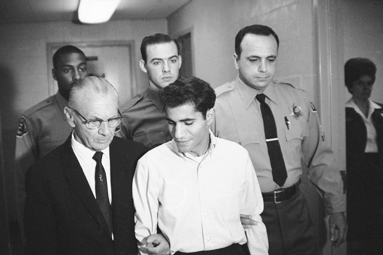 ARCHIVO - En esta fotografía de archivo del 28 de junio de 1968, Sirhan Bishara Sirhan es escoltado por su abogado, Russell E. Parsons desde la capilla de la cárcel del condado de Los Ángeles para declararse culpable de asesinato en Los Ángeles. (AP Photo/George Brich, File)