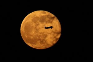 Un avión pasa frente a una luna llena, conocida como la luna del gusano, en Manchester, Gran Bretaña, el 7 de marzo de 2023. 
