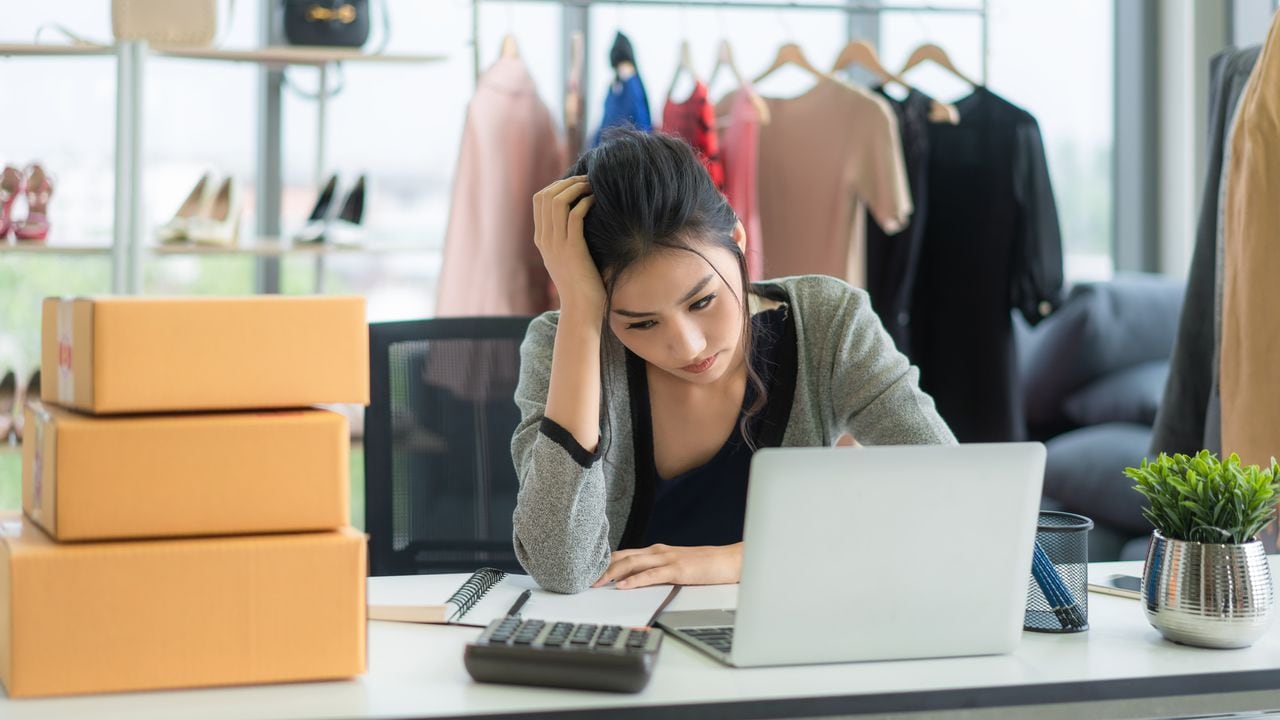 frustrated startup small business owner working at workplace. Asian stressed freelance woman seller check product order for delivery to customer. Failure in Online selling business.