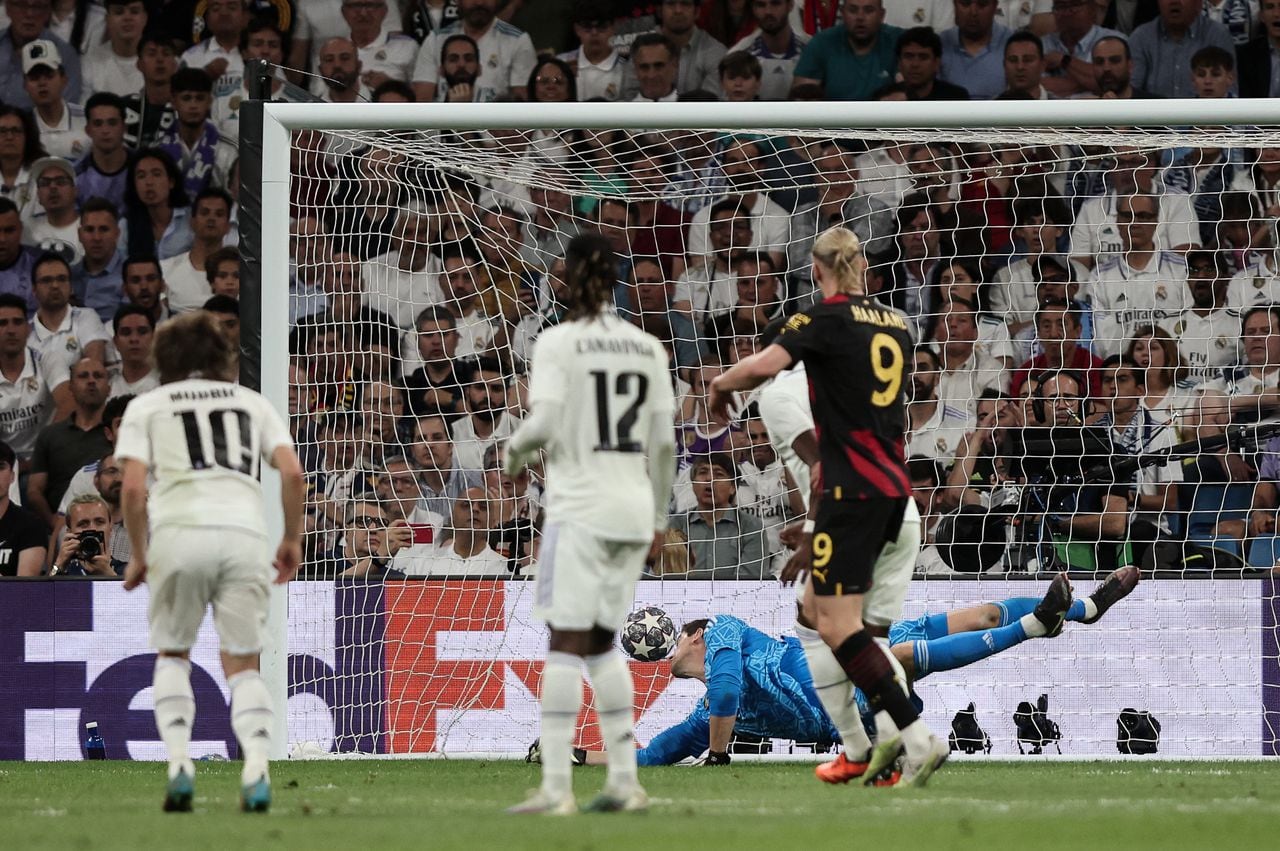 Manchester City's Belgian midfielder Kevin De Bruyne scores his team's first goal in spite of Real Madrid's Belgian goalkeeper Thibaut Courtois during the UEFA Champions League semi-final first leg football match between Real Madrid CF and Manchester City at the Santiago Bernabeu stadium in Madrid on May 9, 2023. (Photo by Thomas COEX / AFP)