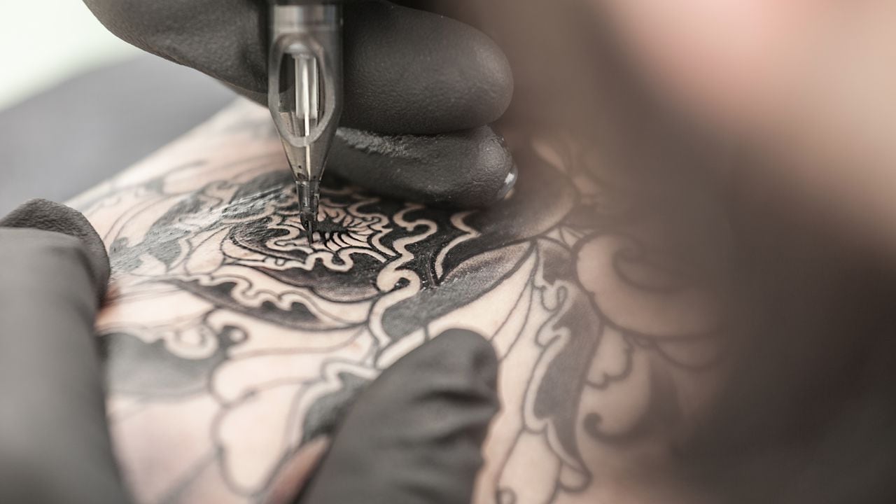 Tattooist drawing on arm of client