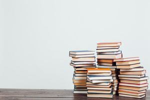 Muchas pilas de libros educativos para enseñar en casa antes de los exámenes sobre un fondo blanco.