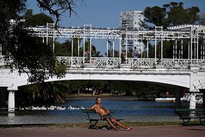 Un hombre toma el sol en el parque El Rosedal en Buenos Aires el 9 de marzo de 2023. Argentina está viviendo el verano más tórrido de este año jamás registrado, con temperaturas récord y escasez de lluvias. (Photo by Luis ROBAYO / AFP)