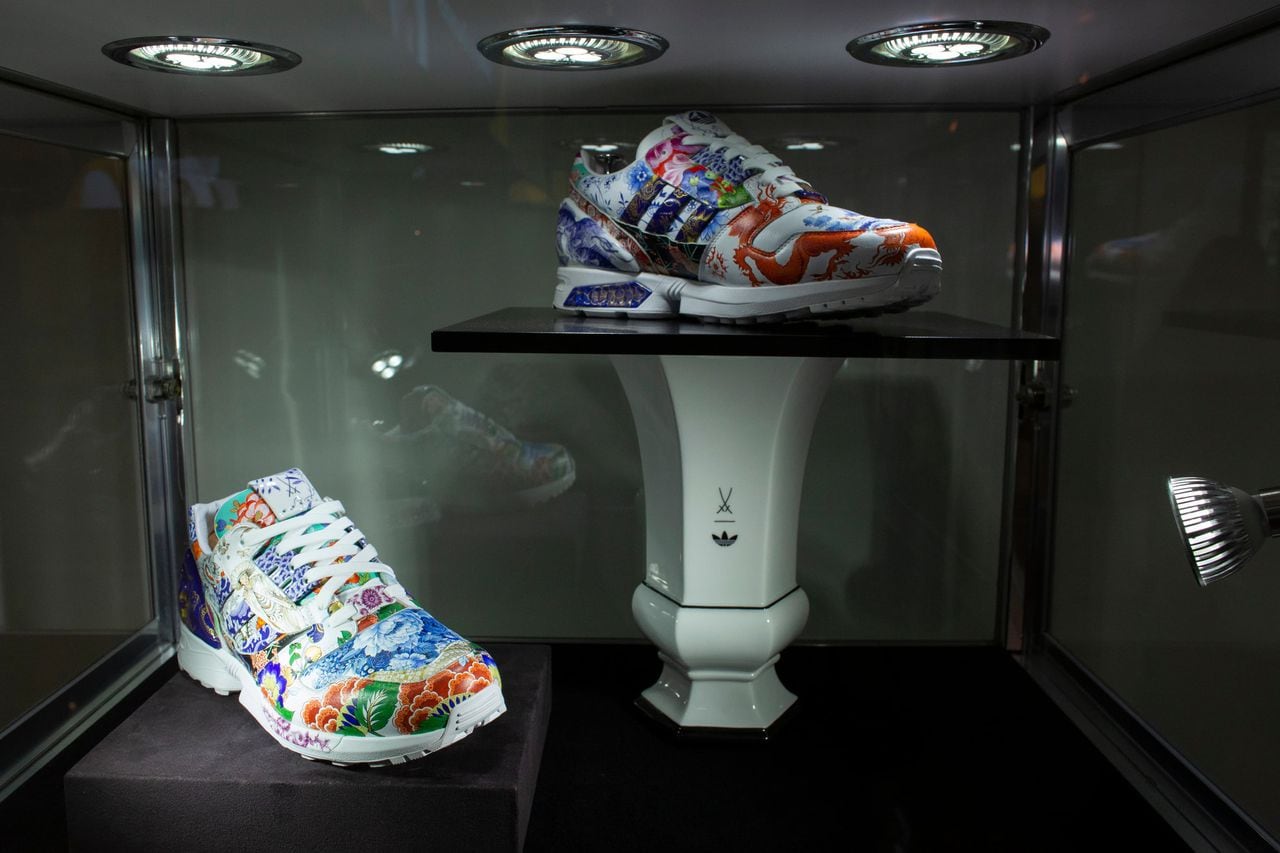 Un manipulador de arte de Sotheby's sostiene unas zapatillas de deporte únicas de Adidas