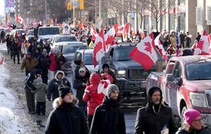 Camiones y simpatizantes viajan por Bloor Street durante una manifestación en apoyo de un convoy de camioneros en Ottawa que protesta por las restricciones del coronavirus.