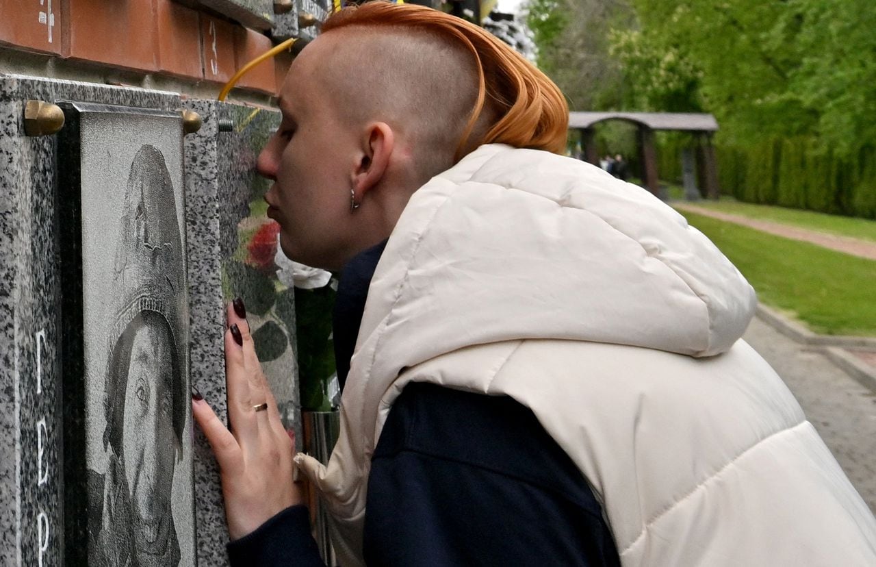Yevgeniya Kolesnichenko besa la placa honorífica a su esposo fallecido.