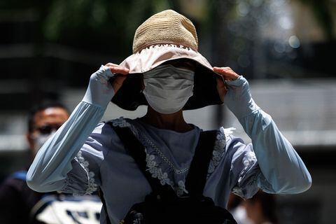 Una persona usa un sombrero y mangas largas protectoras durante una ola de calor en Hong Kong el 9 de julio de 2023.
Mayo JAMES / AFP