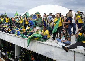 Los manifestantes, partidarios del expresidente de Brasil, Jair Bolsonaro, se paran en el techo del edificio del Congreso Nacional después de que lo asaltaron, en Brasilia, Brasil, el domingo 8 de enero de 2023. (AP Photo/Eraldo Peres, File)