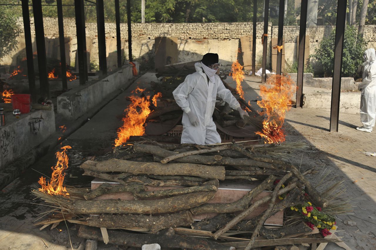 Un familiar de una persona fallecida por el coronavirus, a quien están incinerando, en Jammu, India. (AP Foto/Channi Anand)