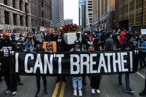 Demonstrators hold placards during the �I Can�t Breathe - Silent March for Justice� in front of the Hennepin County Government Center on March 7, 2021, where the trial of former Minneapolis police officer Derek Chauvin, charged with murdering African American man George Floyd, will begin on March 8, 2021, in Minneapolis, Minnesota. - His name is chanted by demonstrators around the globe. His face is displayed on murals all over the United States. Since his brutal death George Floyd has embodied, more than any other, the Black victims of police violence and racism in the United States. (Photo by CHANDAN KHANNA / AFP)