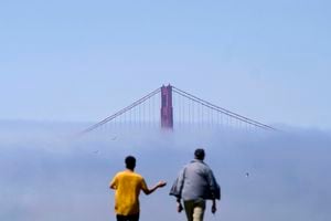 Los peatones caminan sobre una colina frente al puente Golden Gate parcialmente oscurecido por la niebla en San Francisco, el martes 16 de agosto de 2022. Foto AP/Jeff Chiu