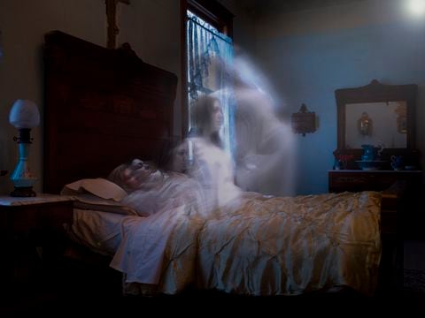 Anciana acostada en la cama con espíritu más joven subiendo desde el cuerpo hacia la fuente de luz