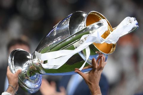 A Real Madrid team member holds the trophy after their victory in the UEFA Champions League final football match between Liverpool and Real Madrid at the Stade de France in Saint-Denis, north of Paris, on May 28, 2022. (Photo by FRANCK FIFE / AFP)