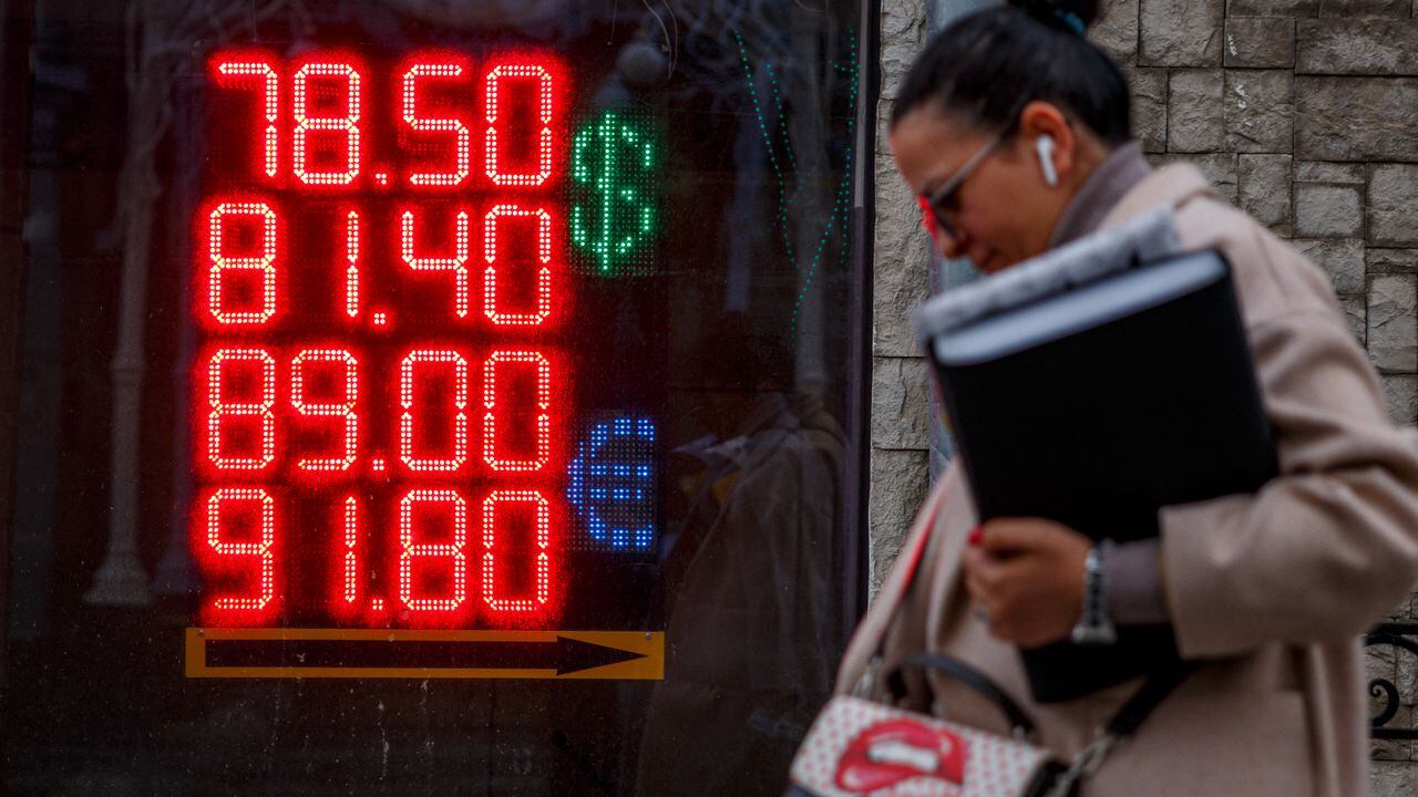 Una mujer pasa junto a una casa de cambio en la que se ve la tasa de cambio del dólar americano y el euro con respecto al rublo ruso. Moscú, 22 de febrero de 2022. Foto: Dimitar Dilkoff / AFP