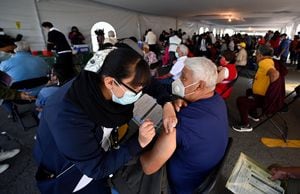 Un hombre recibe la tercera dosis de la vacuna AstraZeneca contra COVID-19 en la Ciudad de México, el 4 de enero de 2022. (Foto de ALFREDO ESTRELLA / AFP)