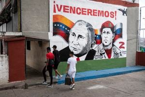 Jóvenes caminan frente a un mural pintado por la brigada muralista zapatista de la comunidad de La Piedrita y que representa al presidente ruso Vladimir Putin junto al difunto presidente venezolano Hugo Chávez. (Photo by Yuri CORTEZ / AFP)