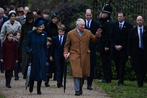 (FILES) Britain's King Charles III (R) flanked by Britain's Camilla, Queen Consort (L) waves to members of the public as he arrives for the Royal Family's traditional Christmas Day service at St Mary Magdalene Church in Sandringham, Norfolk, eastern England, on December 25, 2022. Britain's Charles III reaches the milestone of his first year as king this week, with his reign so far characterised by a smooth transition from that of his late mother, Queen Elizabeth II. (Photo by Daniel LEAL / AFP)